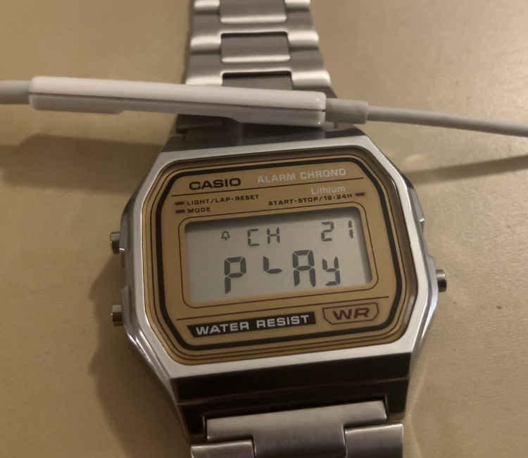 A CASIO wristwach with a headset microphone placed over it